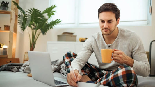 Man drinking organic mushroom coffe in the morning while working on a laptop